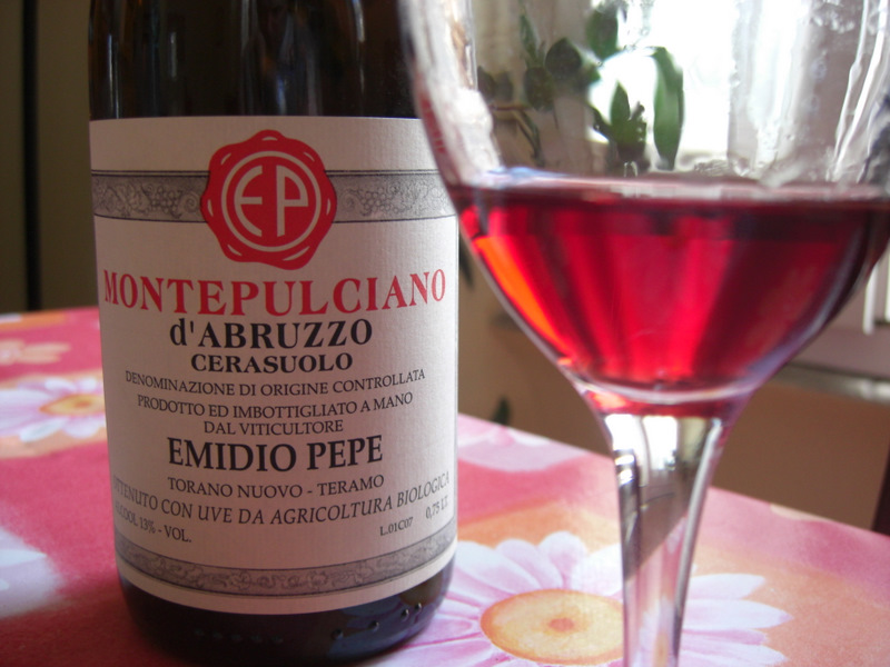 「MONTEPULCIANO d'ABRUZZO CERASUOLO」と書かれた瓶と、濃いピンク色のワインが入ったグラス