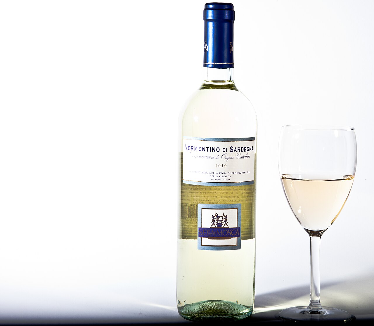 「VERMENTINO DI SARDEGNA」と書かれたラベルの白ワインの瓶と、ワインを注いだグラス